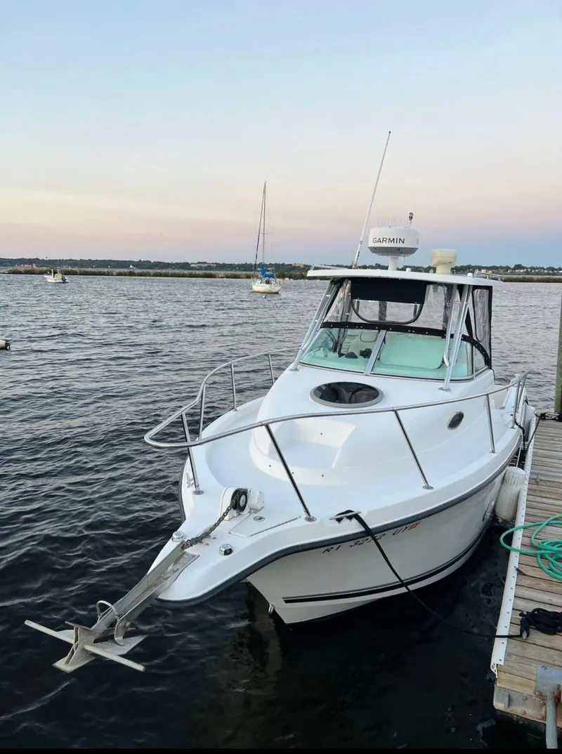 Slide: The Image of 2002 Seaswirl Striper 2601 Walkaround boat docked on calm water. - 2