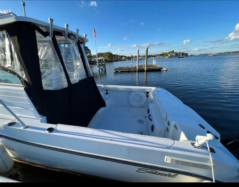 Slide: The Image of 2002 Seaswirl Striper 2601 Walkaround boat docked by a scenic waterfront. - 4