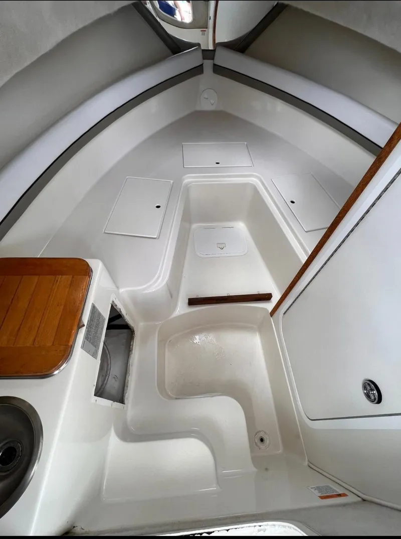 Slide: The Image of 2002 Seaswirl Striper 2601 Walkaround cabin interior with white seating and wood accents. - 9