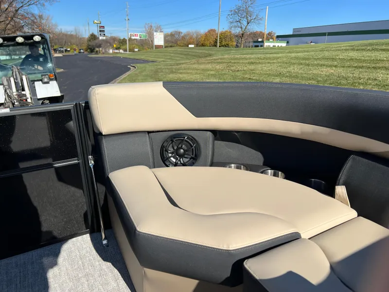 Slide: The Image of 2025 South Bay 220RS boat interior with beige and black seating, speaker, and cup holders. - 22