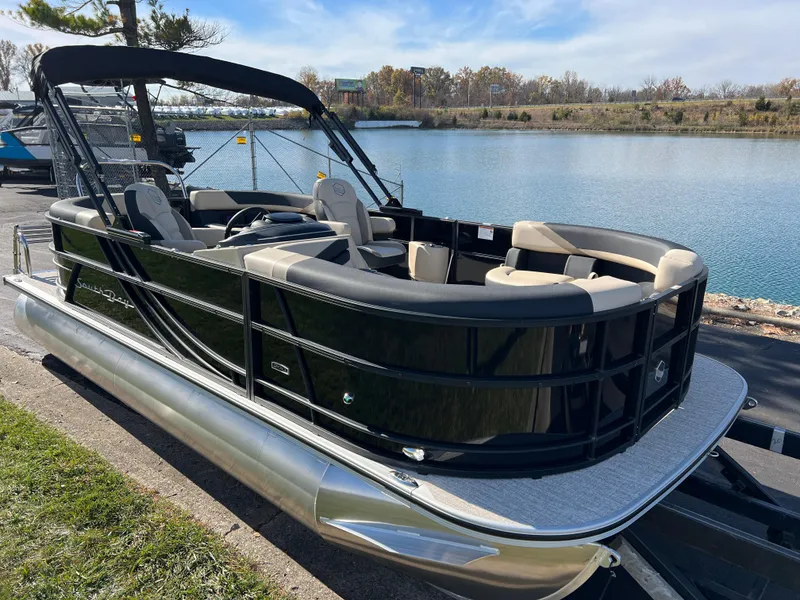 Slide: The Image of 2025 South Bay 220RS pontoon boat docked by a serene lake. - 3