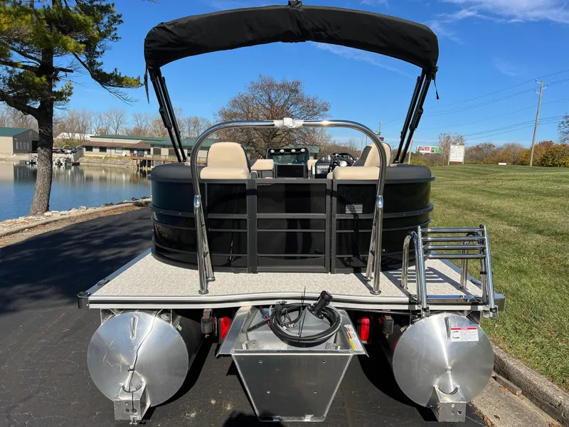 Slide: The Image of 2025 South Bay 220RS pontoon boat, rear view, parked near a lake on a sunny day. - 5