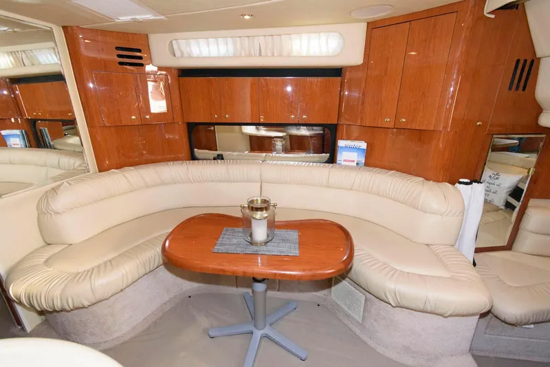Slide: The Image of Luxurious interior of 2000 Sea Ray 380 Sundancer with curved seating and wooden table. - 17