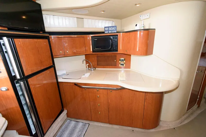 Slide: The Image of Interior of 2000 Sea Ray 380 Sundancer yacht kitchen with wood cabinets and appliances. - 18