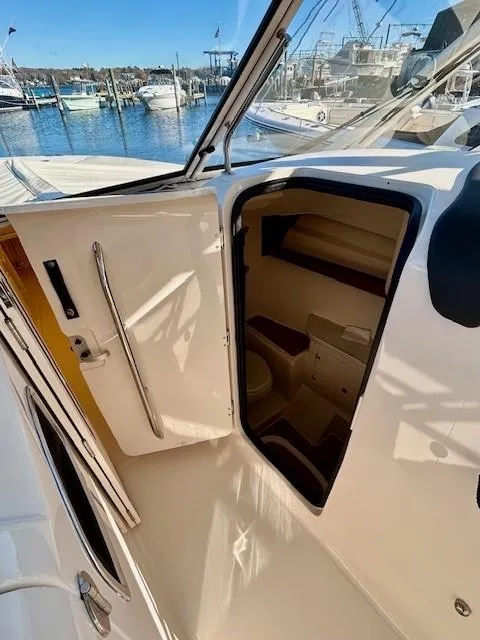 Slide: The Image of 2022 Grady-White Freedom 335 boat interior with open cabin door at marina. - 22
