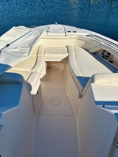 Slide: The Image of 2022 Grady-White Freedom 335 boat interior with white seating and blue water backdrop. - 27