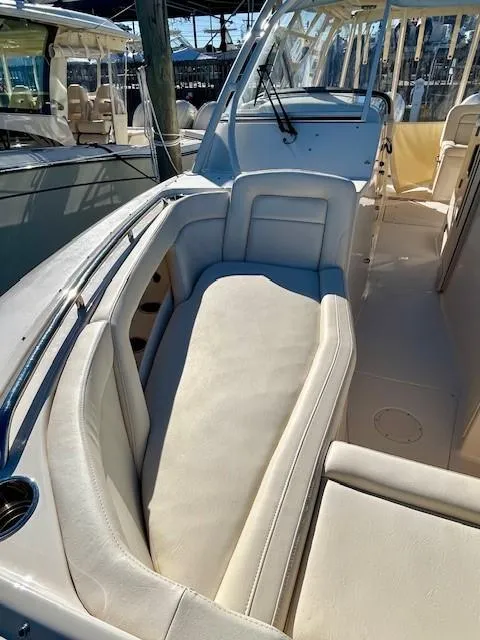 Slide: The Image of 2022 Grady-White Freedom 335 boat interior with cushioned seating and helm. - 29