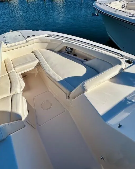Slide: The Image of 2022 Grady-White Freedom 335 boat interior with white seating and blue water background. - 30