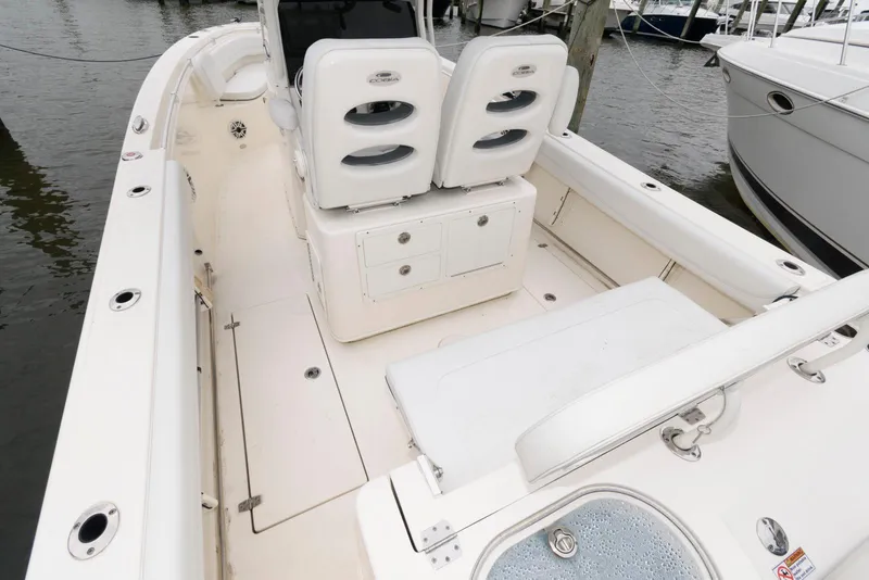 Slide: The Image of 2020 Cobia 262 Center Console boat interior with seating and storage, docked at marina. - 11