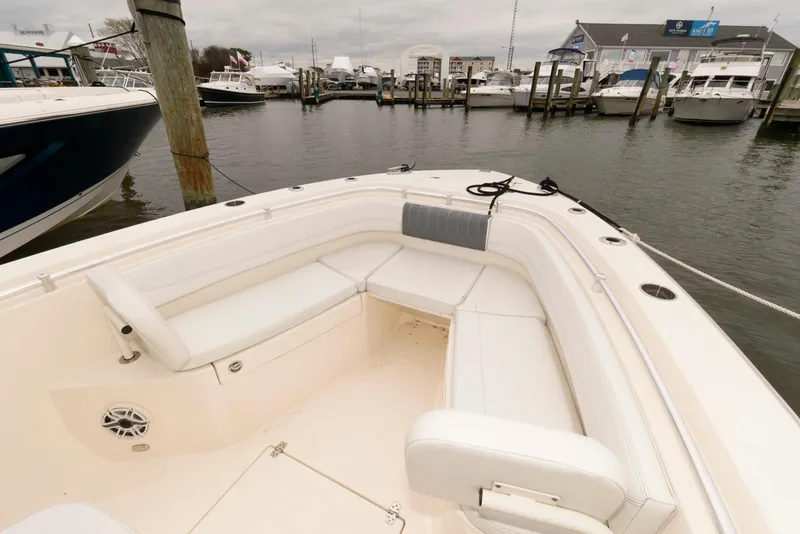 Slide: The Image of 2020 Cobia 262 Center Console boat docked at a marina with spacious seating. - 12