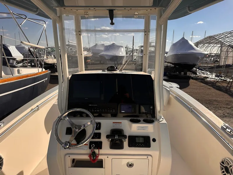 Slide: The Image of 2020 Cobia 262 Center Console boat dashboard with steering wheel and controls. - 13