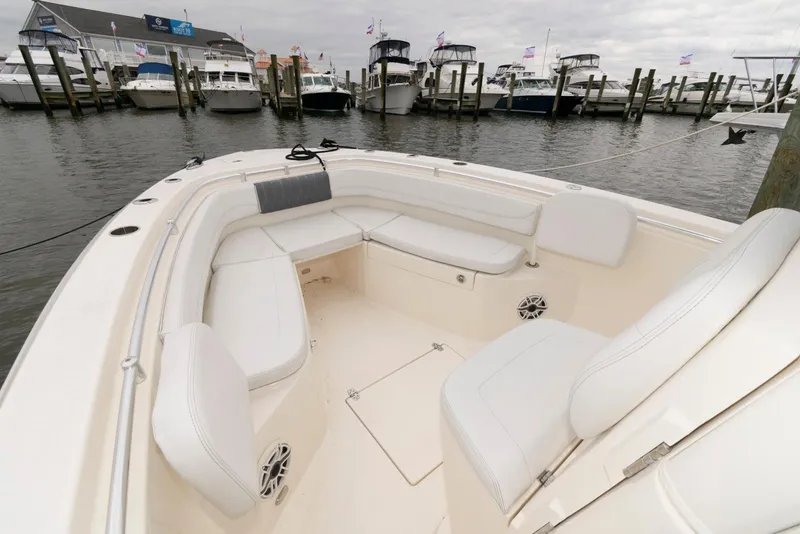 Slide: The Image of 2020 Cobia 262 Center Console boat with white seating at a marina. - 18