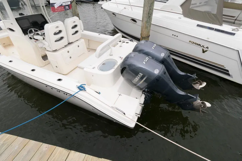 Slide: The Image of 2020 Cobia 262 Center Console boat with twin Yamaha engines docked at marina. - 2