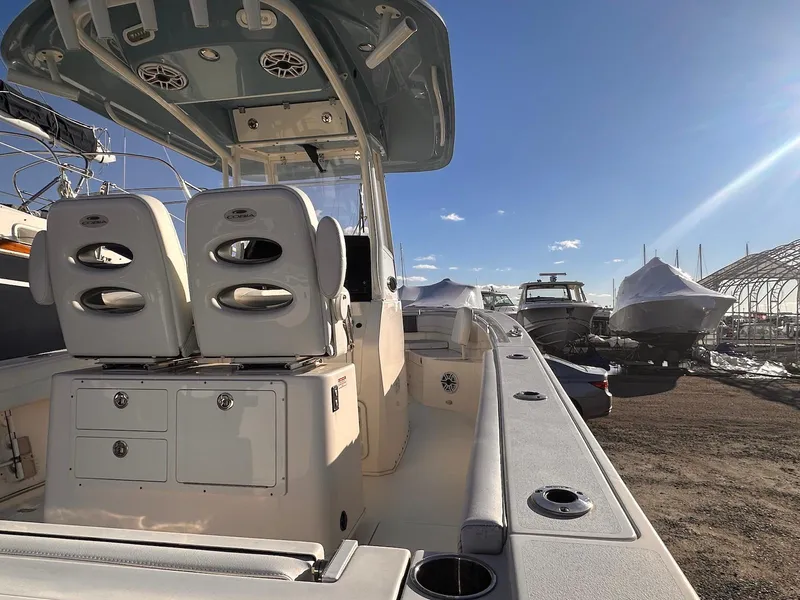 Slide: The Image of 2020 Cobia 262 Center Console boat in a sunny marina setting. - 6