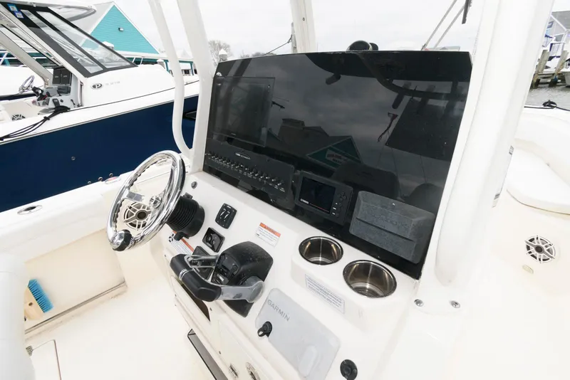 Slide: The Image of 2020 Cobia 262 Center Console boat dashboard with steering wheel and controls. - 8