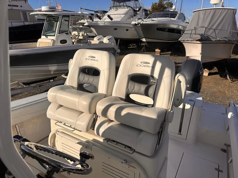 Slide: The Image of 2020 Cobia 262 Center Console boat with dual seats in a marina setting. - 9