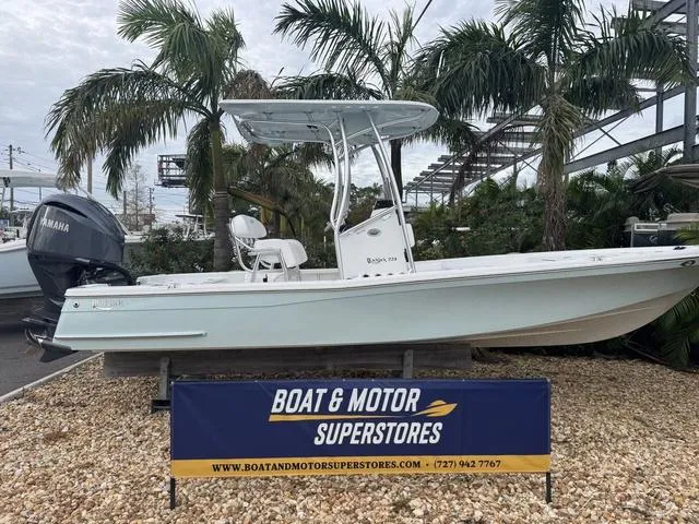 Slide: The Image of 2025 BlackJack 224 boat displayed at Boat & Motor Superstores, surrounded by palm trees. - 1