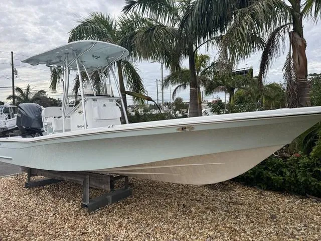 Slide: The Image of 2025 BlackJack 224 boat displayed outdoors with palm trees in the background. - 10