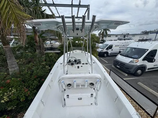 Slide: The Image of 2025 BlackJack 224 boat with T-top, parked near palm trees and service vans. - 14