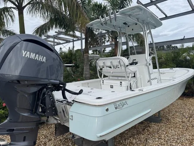 Slide: The Image of 2025 BlackJack 224 boat with Yamaha engine, parked outdoors near palm trees. - 3