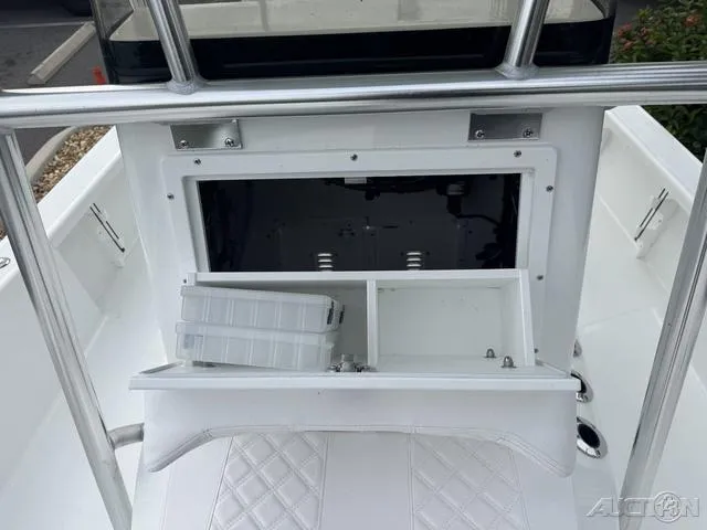 Slide: The Image of 2025 BlackJack 224 boat storage compartment with open hatch and tackle box. - 32
