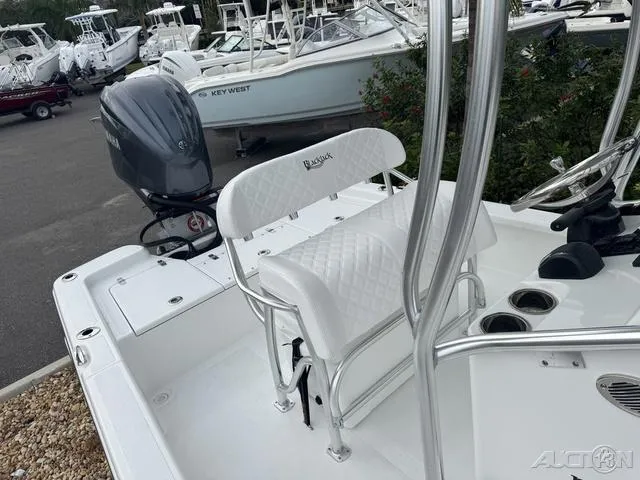 Slide: The Image of 2025 BlackJack 224 boat with white seating and Yamaha outboard motor in a marina. - 33