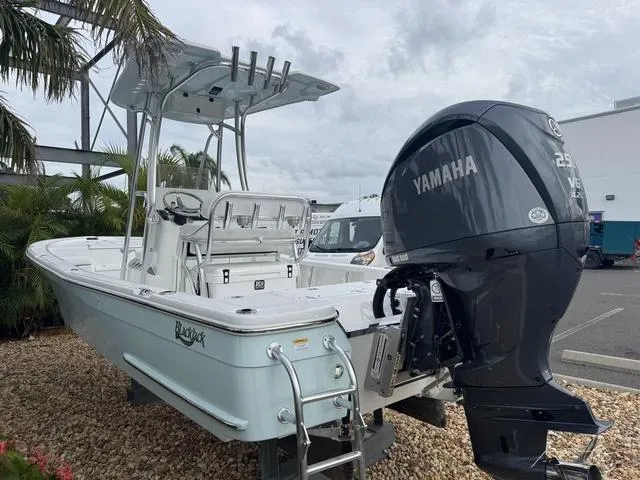 Slide: The Image of 2025 BlackJack 224 boat with Yamaha engine, parked outdoors on gravel. - 9