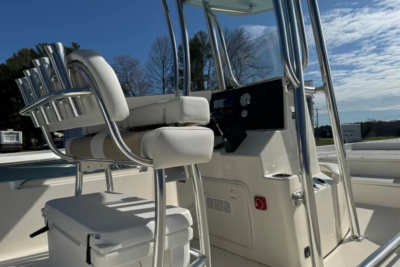 Slide: The Image of 2026 Bulls Bay 2400 boat interior with cushioned seating and control panel under clear sky. - 10