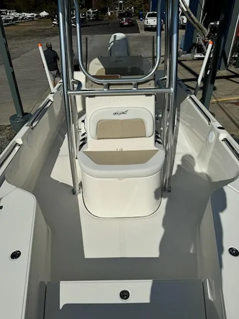 Slide: The Image of 2025 Bulls Bay 2400 boat interior with seating and console, docked outdoors. - 2