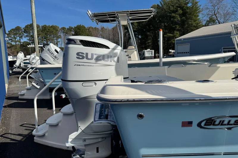 Slide: The Image of 2026 Bulls Bay 2400 boat with Suzuki outboard motor in a marina setting. - 8