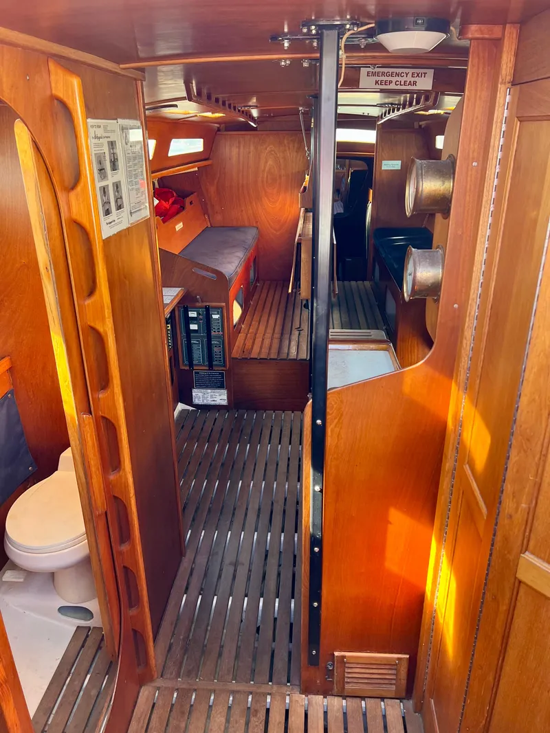 Slide: The Image of Interior of a 1985 Santa Cruz 50 yacht, featuring wooden finishes and compact design. - 17