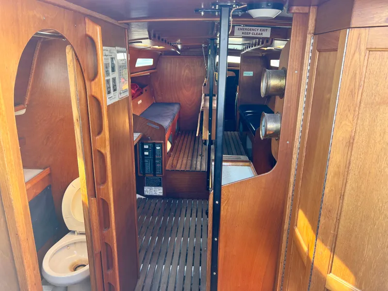 Slide: The Image of Interior of a 1985 Santa Cruz 50 sailboat, featuring wooden paneling and compact living space. - 18