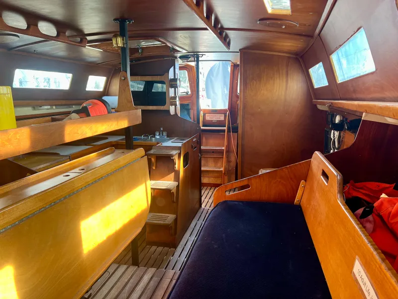 Slide: The Image of Interior of a 1985 Santa Cruz 50 sailboat, featuring wooden furnishings and seating. - 19