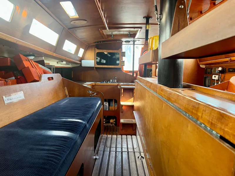 Slide: The Image of Interior of a 1985 Santa Cruz 50 sailboat, featuring wooden finishes and seating area. - 21
