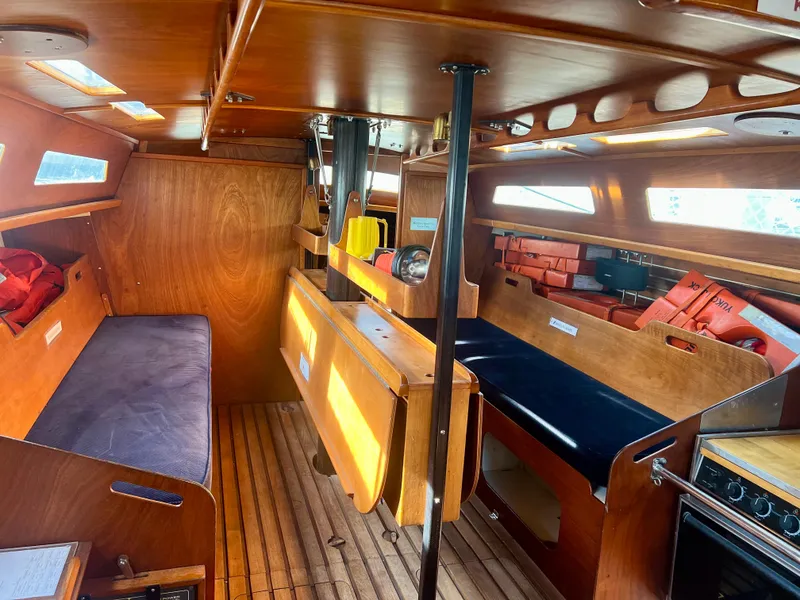 Slide: The Image of Interior of a 1985 Santa Cruz 50 sailboat with wooden furnishings and seating. - 23