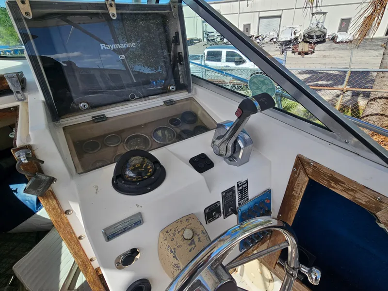 Slide: The Image of 1985 Grady-White 228 Seafarer boat dashboard with steering wheel and controls. - 22