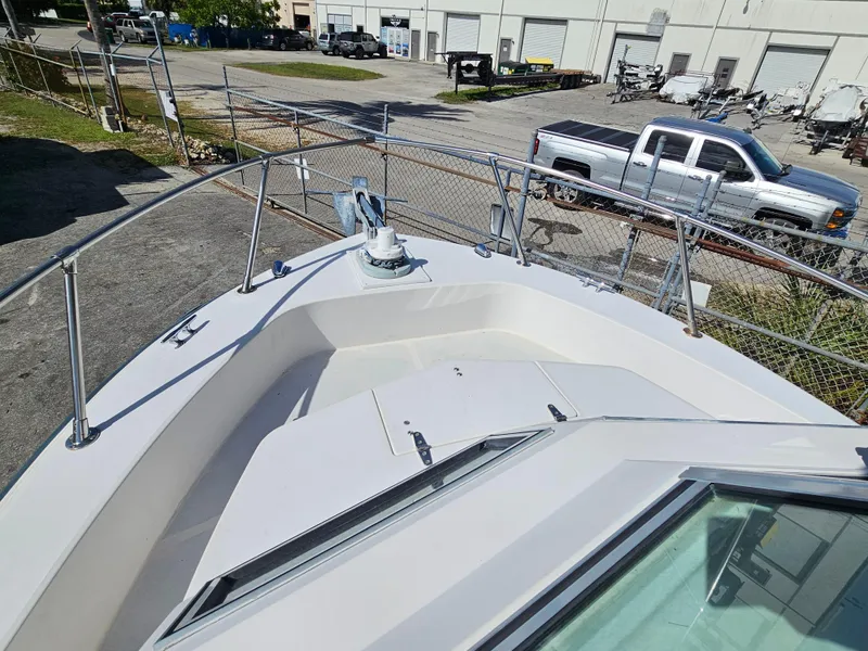 Slide: The Image of 1985 Grady-White 228 Seafarer boat deck with railing and anchor, parked near industrial area. - 23