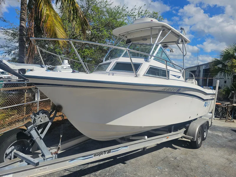 Slide: The Image of 1985 Grady-White 228 Seafarer boat on trailer, parked outdoors under blue sky. - 4