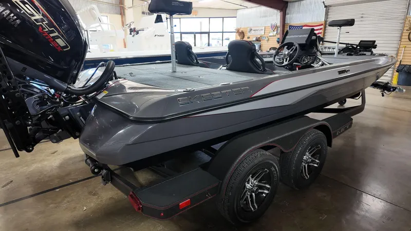 Slide: The Image of 2025 Skeeter ZXR 21 boat in showroom, featuring sleek design and dual axle trailer. - 5