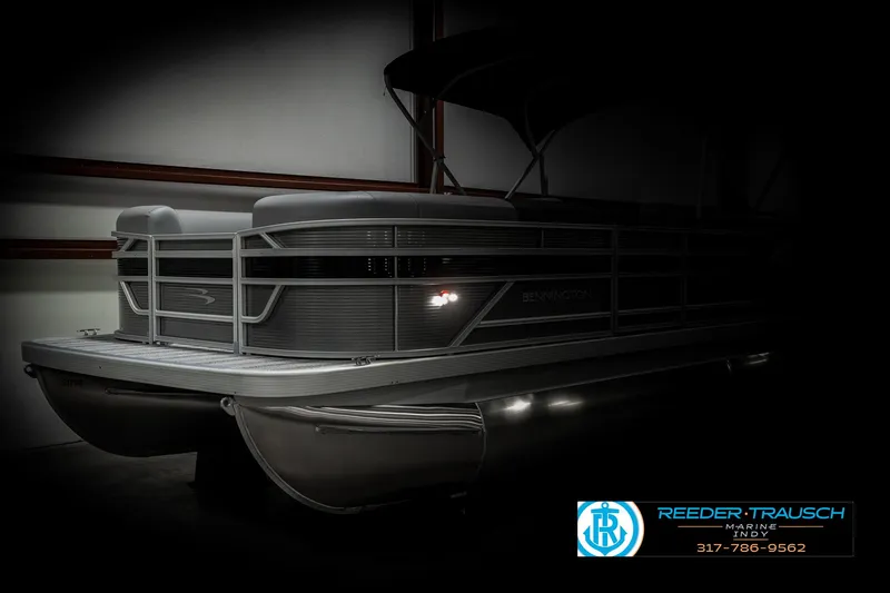 Slide: The Image of 2025 Bennington 22 SLSE pontoon boat in dimly lit showroom. - 4