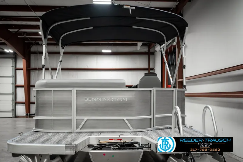 Slide: The Image of 2025 Bennington 22 SLSE pontoon boat in indoor showroom with canopy. - 6