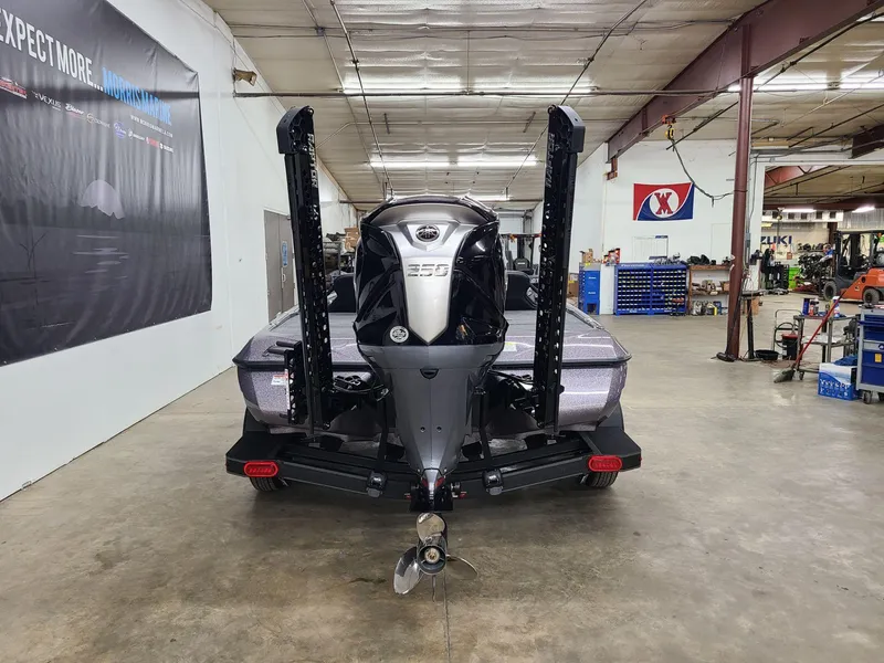 Slide: The Image of 2024 Skeeter ZXR 20 boat in a workshop, rear view with motor and propeller. - 1