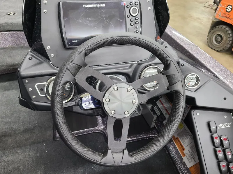 Slide: The Image of 2024 Skeeter ZX 200 boat dashboard with steering wheel and Humminbird display. - 13