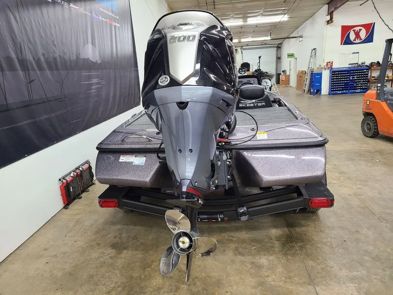 Slide: The Image of 2024 Skeeter ZX 200 boat in a garage, showcasing rear view and motor. - 2