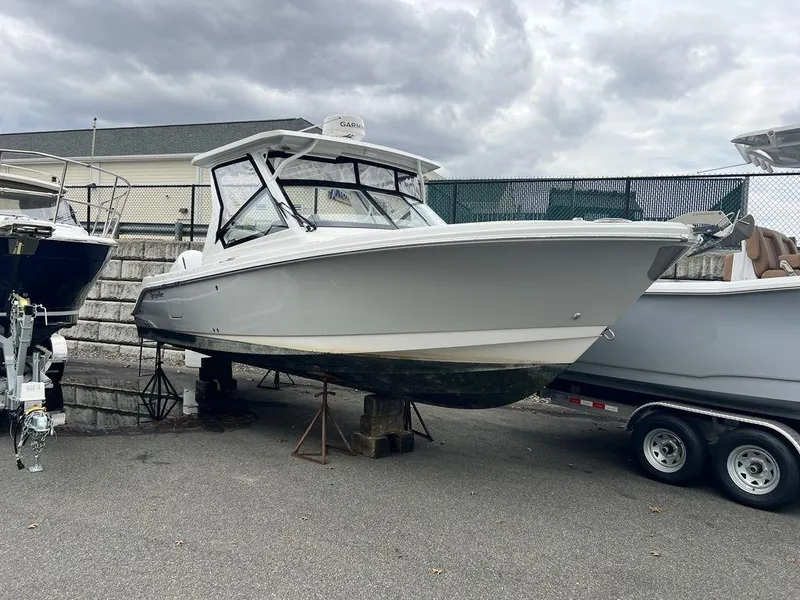 Slide: The Image of 2022 Edgewater 262CX boat on trailer under cloudy sky. - 2