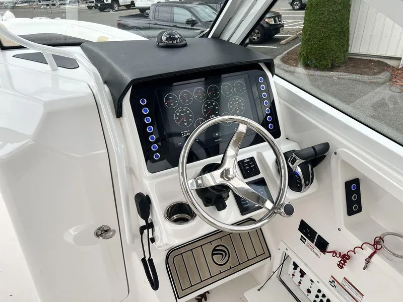 Slide: The Image of Edgewater 262CX 2022 boat dashboard with steering wheel and control panel. - 6