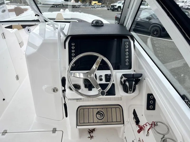 Slide: The Image of Edgewater 262CX 2022 boat dashboard with steering wheel and control panel. - 9