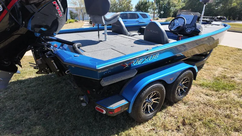 Slide: The Image of 2023 Vexus AVX2080 boat on trailer, blue exterior, parked on grass. - 2