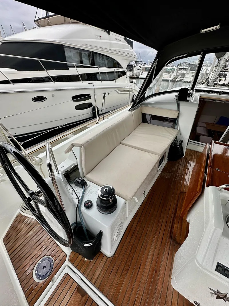 Slide: The Image of 2020 Jeanneau Sun Odyssey 490 cockpit with seating, steering wheel, and wooden deck. - 14