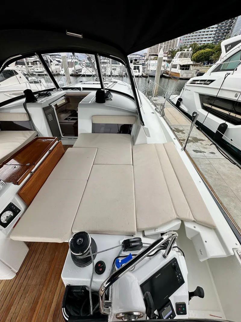 Slide: The Image of 2020 Jeanneau Sun Odyssey 490 yacht interior at marina, featuring spacious seating and modern controls. - 19